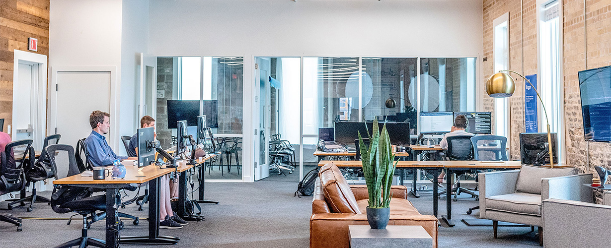 3 persons working inside an open concept office